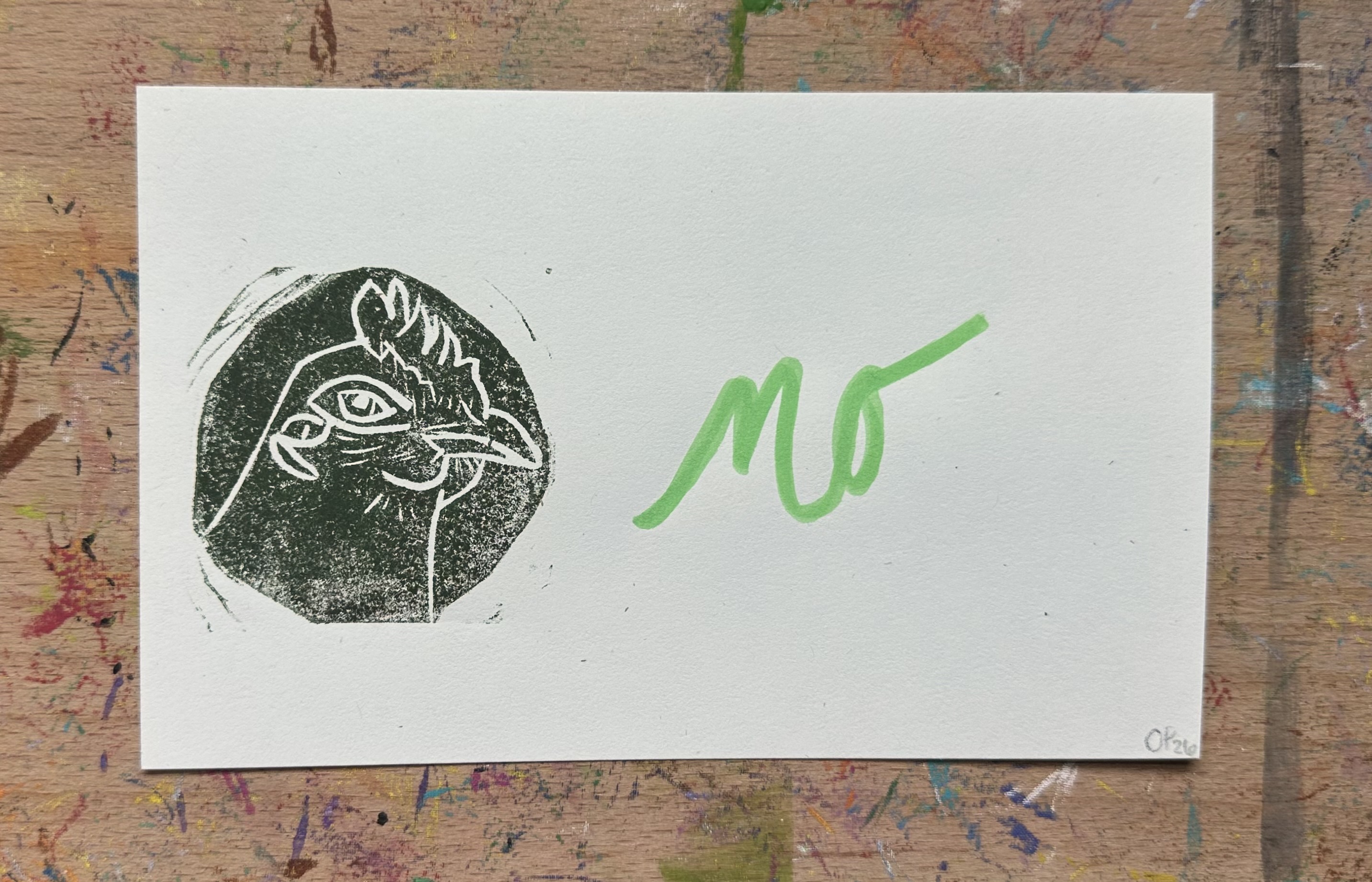 Rectangular piece of off white paper. A dark green/brown block print of a chicken in profile witha knowing look on the left. "no" written on the right.