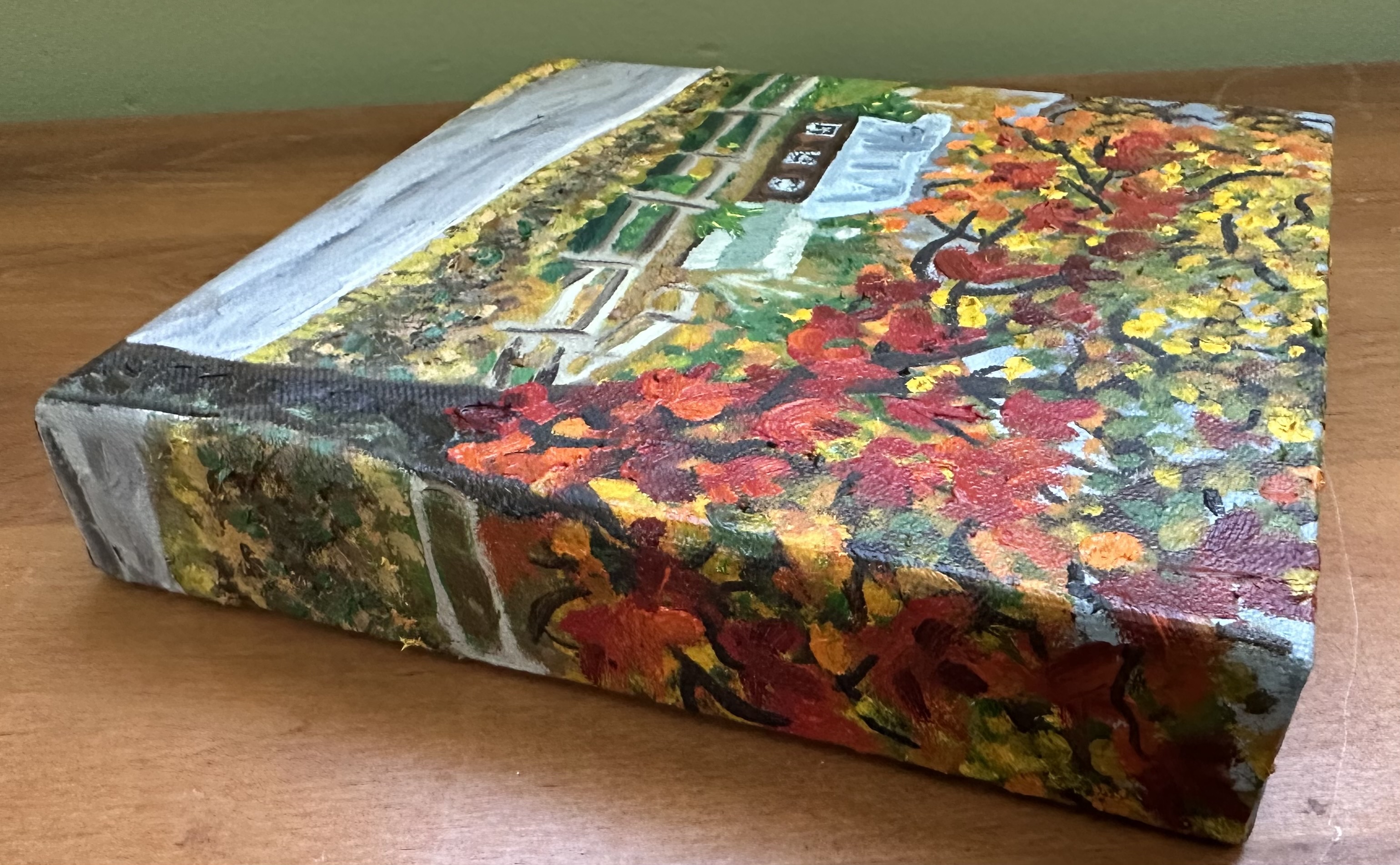 The right side of the painting with a view of the front. Some branches with leaves of the front tree continues around with a bit of the fence, leaf covered ground, and the road seen below.