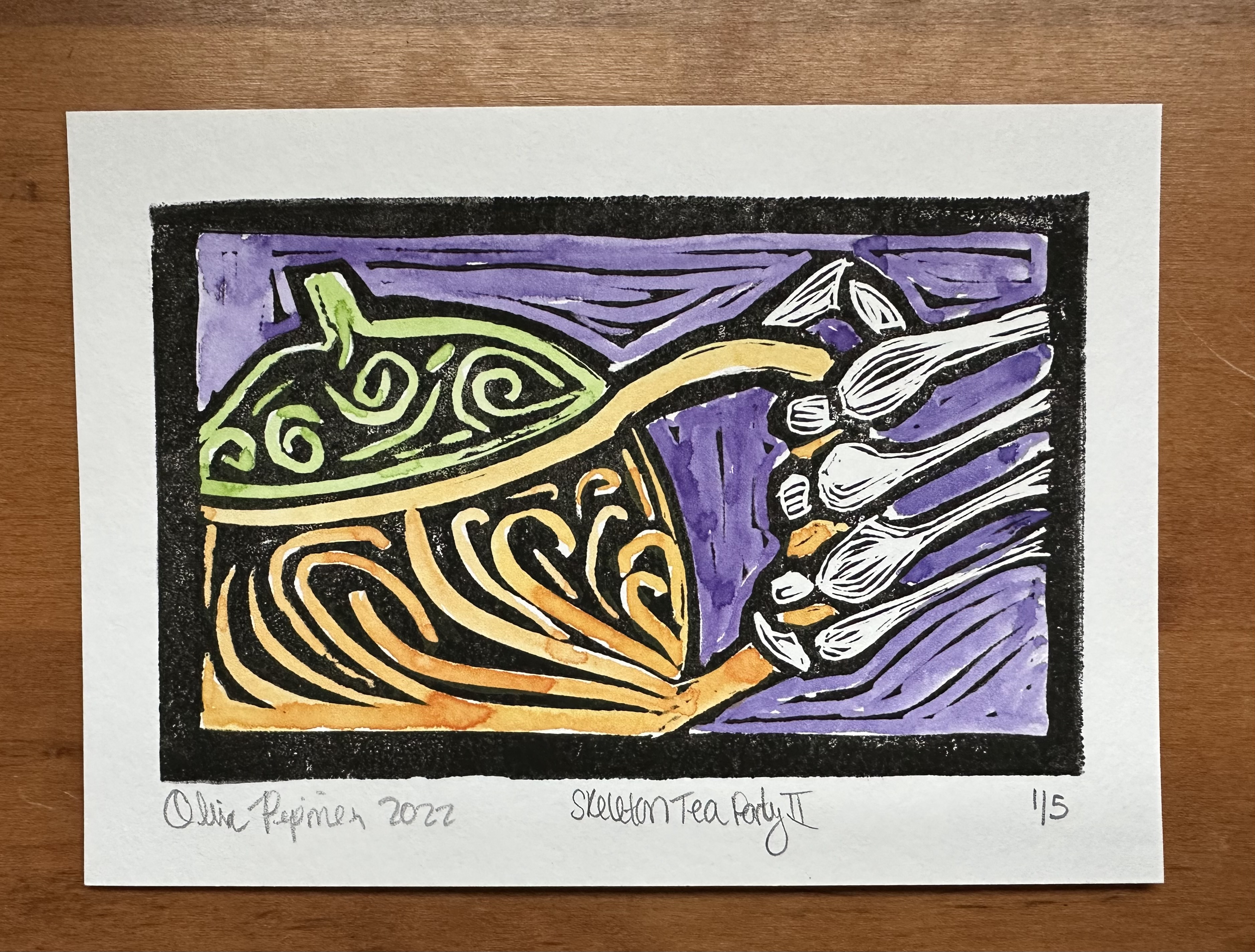 Most of the print is taken up by a teapot with decorative swirls on it sort of in the shape of a pumpkin - the lid is light green and the rest of orange. The background of the print is painted purple and a skeleton hand comes from the right to hold the teapot handle. Underneath the print is a black blob on the left (the signature blacked out) with "2022," "Skeleton Tea Party II" in the center, with 1/5 on the far right.