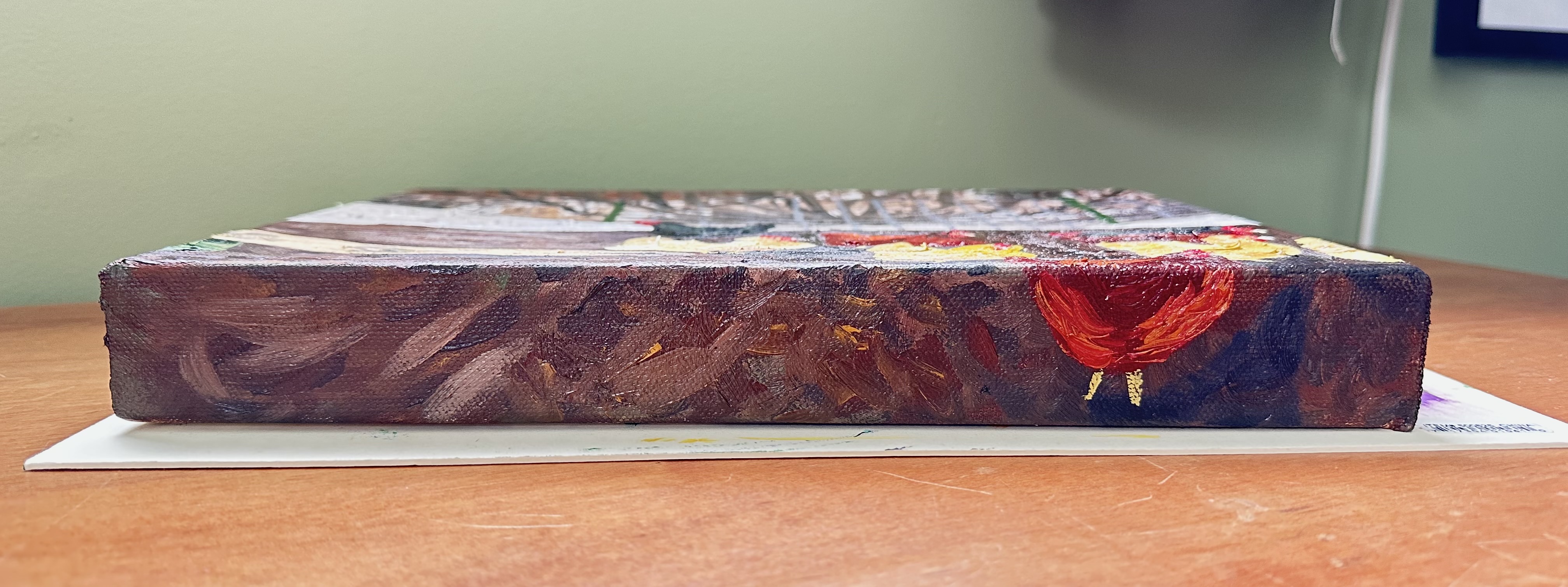 The bottom of the painting. It's mostly mud with the bottom half of a red chicken to the far right.